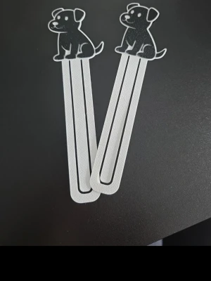 Svarta bokmärken med hundmotiv - Två bokmärken i svart och vitt med söta hundmotiv upptill. Tillverkade i plast med stilren och lekfull design, perfekta för att hålla koll på var du är i boken.