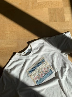 Sötaste vintage t-shirt 😍😍😍💕 - En helt unik vintage t-shirt med ett broderat sommar motiv av blommor och trollsländor. Har även en söt liten trollslända på ena armen 😍Perfekt för dig som gillar unika detaljer och konstnärliga prints 🌸( är i storlek L men går utmärkt som overzie ) 💕