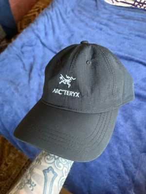 Arcteryx keps - Säljer en äldre, mer ovanlig Arc’teryx keps i svart. Klassisk minimalistisk modell med broderad logga och metalljustering bak.  Använd sparsamt och i mycket fint skick. Svår att hitta i denna äldre version.  Perfekt för både outdoor och vardag