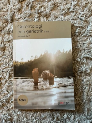 Gerontologi och geriatrik Nivå 1 - Säljer kursboken 'Gerontologi och geriatrik Nivå 1' av Eva-Lena Lindqvist. Boken har ett beige och vitt omslag med ett foto på en person som badar i solnedgång. Perfekt för dig som pluggar vård och omsorg och vill lära dig mer om äldreomsorg, sjukdomar och kommunikation.