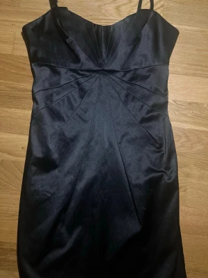 Svart kort klänning med smala axelband - Stilren svart kort klänning. Storlek XS. Knappt Använd.