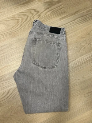 Grå jeans från Vailent - Säljer ett par grå jeans från Vailent med rak passform och klassisk femficksdesign. Jeansen har en ljusgrå tvätt och är tillverkade och är perfekta för en avslappnad och trendig look.
