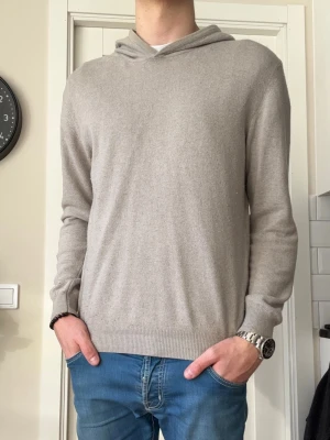 Oscar Jacobson hoodie  - Oscar Jacobson Pascal hoodie i storlek M, fin sand/beige färg. Materialet är en ull/kashmir blandning, passar både till vardagens men även festligare tillfällen. Köpt helt ny från VOLT. Hör av dig vid frågor!