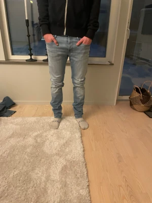 Replay jeans ljusblå  - Tja säljer ett par riktigt schyssta och Snygga ljusblå slim fit jeans från replay med klassisk femficksdesign och diskreta slitningar hål i knät för extra detalj vilket är riktigt snyggt. Jeansen har normal midja och raka ben, perfekta för en avslappnad och trendig look. Modell är replay anbass och storlek 34/34 killen på bilderna är 183 cm lång, skick 10/10🤗hör av dig vid mer frågor eller funderingar🙌🏼mvh premium fashion