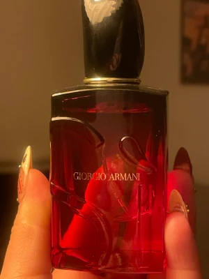 Giorgio Armani Si Red Passione Intense 50ml - Elegant parfym från Giorgio Armani i en djup röd glasflaska med dekorativa mönster. Flaskan har en svart och guld kork som ger en lyxig känsla. Volymen är 50 ml och flaskan har tydlig märkning undertill. Perfekt för dig som gillar exklusiva dofter.