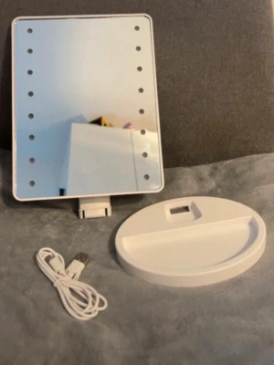 Sminkspegel med LED-belysning - Snygg sminkspegel i vit plast med rektangulär form och inbyggd LED-belysning runt spegeln. Touch-knapp på framsidan för att justera ljuset. Spegeln kommer med en avtagbar fot och USB-kabel för laddning. Perfekt för smink och styling.