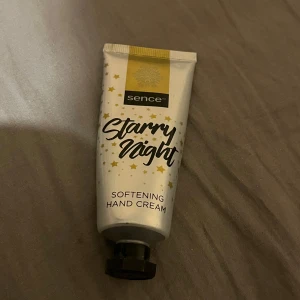 Sence Starry Night handkräm - Mjukgörande handkräm från Sence i tub med gulddetaljer och stjärnmotiv. Tuben är vit med svart text och har ett svart lock. Perfekt för att hålla händerna återfuktade och mjuka.