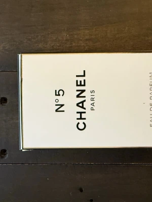 Chanel No 5 Eau de Parfum - Klassisk Chanel No 5 Eau de Parfum i elegant vit och svart kartong med guldiga detaljer. Parfymen är ikonisk och tidlös, perfekt för dig som gillar exklusiva dofter.  Säljer då doften inte passade mig.
