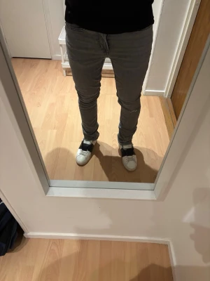Gråa slim fit jeans - Säljer ett par gråa slim fit jeans med klassisk femficksdesign och dragkedjegylf. Jeansen har en smal passform som sitter tajt längs benen och är perfekta för en modern och avslappnad stil. Materialet är mjukt och stretchigt för extra komfort. Storleken 29/32