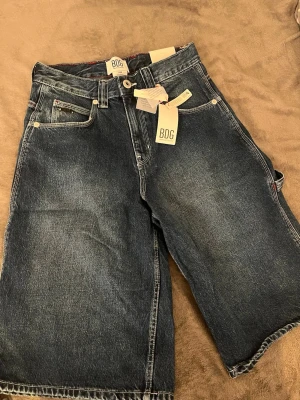 BDG Jeans Jorts - Säljer ett par Jorts från BDG, köpt från urban outfitters. Oanvända. Prislapp fortfarande kvar. Storlek 26W. Storlek: 34-36. Original pris: 550kr. 