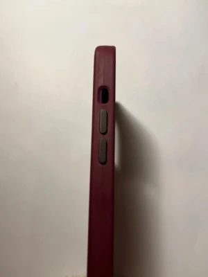 Mörkrött mobilskal med knappar - Snyggt vinrödd  mobilskal med gråa knappar på sidan. Skalet har en stilren och enkel design som skyddar mobilen effektivt. Tillverkat i ett tåligt material som ger bra grepp och passar perfekt för dig som vill ha ett diskret men färgstarkt tillbehör.