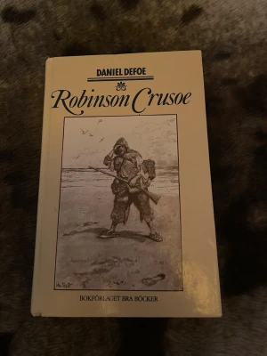 Robinson Crusoe av Daniel Defoe - Klassikern Robinson Crusoe av Daniel Defoe i hårdpärm med beige omslag och svartvit illustration på framsidan. Boken är utgiven av Bokförlaget Bra Böcker och ingår i serien Alla Tiders Klassiker. Perfekt för dig som gillar äventyr och tidlösa berättelser.