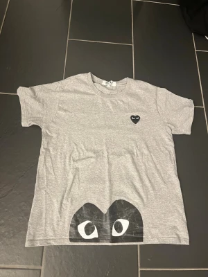 CDG T-shirt - Säljer denna eleganta T-shirt från märket Commes de garçons. Storleken är L men sitter mer som en S/M. Skick 7/10 lite använd men annars inget märkvärdigt.