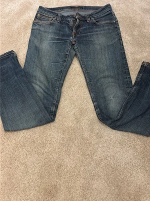 Nudie Jeans - Säljer ett par snygga nudie jeans i slim fit W29 L32 men passar mer som L31-30, jeansen är i bra skick förutom två hål vid skrevet men det går att fixa hos en nudie butik gratis. Tveka inte på att fråga om ni undrar något