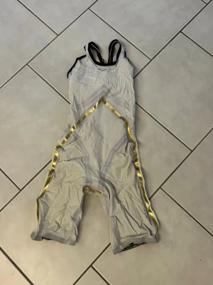 Finis Rival 2.0 tävlingsbaddräkt - Säljer 4 Finis Rival 2.0 tävlingsbaddräkter med ben, en i svart med silverdetaljer och en i ljusgrått, en blå och en vit med gulddetaljer. Den svarta är lite mer sliten än de andra.  Medföljer originalpåse till alla. Svarta och vita är högkompression och de andra är lågkompsression. Pris går att diskutera. Blå och grå: 1200kr/baddräkt. Vita: 1900kr. Svarta 1300kr. Alla är storlek 28. Även två träningsbaddräkter den längst till höger storlek 32. Pris 200. Andra storlek 30, oanvänd. Pris 300