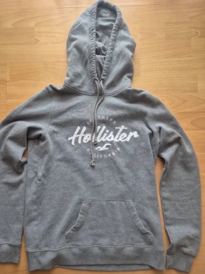 Vintage hollister hoodie - Snygg grå hoodie från Hollister, modellen är vintage som är extremt eftertraktad i nuläget🤩🤩, skicket är mycket bra då tecken på användning inte finns. Storleken är M men passar S. Startpriset börjar på 599 men kan diskuteras😊(tröjan kommer in nästa vecka så var först att reservera)