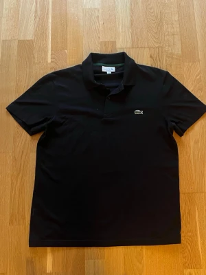 Lacoste piké  - Svart Lacoste piké, 10/10 skick, endast använd ett fåtal gånger, storlek M,kan mötas runt om göteborg 