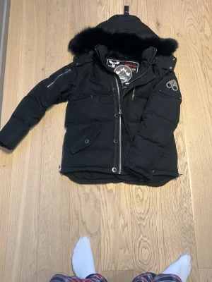 Moose Knuckles jacka - Säljer en Moose Knuckles-jacka i nyskick, använd endast en gång. Prislapp sitter fortfarande kvar, vilket gör att jackan i princip är som ny från butik. Inga skador, fläckar, lukt eller slitage – helt felfritt skick.  Jackan är i storlek S, men är relativt rymlig i modellen och sitter perfekt på mig som är 183 cm. 