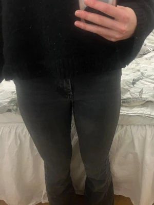 Svarta bootcut jeans med medelhög midja - Säljer ett par svarta bootcut jeans och midwaist midja. Jeansen har klassisk femficksdesign och stängs med dragkedja och knapp. Perfekta till en avslappnad stil och funkar året runt. Storlek XS/30