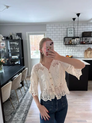 Vit spetsblus med trekvartsärmar  - Superfin vit spetsblus med knappar framtill och broderad spets. Blusen har trekvartsärmar och en lätt v-ringning. Den har fina detaljer längs kanterna. Köpt i en butik i Frankrike, vet därför inte märke. Publicerad på flera säljsidor 🌸 