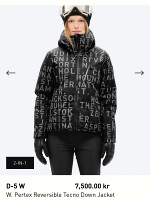 Svart vändbar dunjacka D-5 W - Snygg vändbar dunjacka i svart från Mountin studio med Pertex-material. Ena sidan är helsvart och andra har svart botten med stora vita bokstäver. Jackan har huva, dragkedja och en modern, boxig passform. Perfekt för kalla vinterdagar. Köpt förra vintern och använd en halv säsong!!! OBS!! En liten rep på luvan, som är lagad och knappt syns. Väldigt najs eftersom den har två olika sidor, ena mer skid vibe och andra som en vanlig snygg dunjacka.