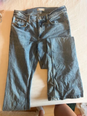 Ljusblå flare gina jeans- pris kan diskuteras - Säljer ett par ljusblå jeans med lite bootcut passform och klassiska fem fickor. Jeansen har normal midja och stängs med dragkedja och knapp. Perfekta för en avslappnad och stilren look.