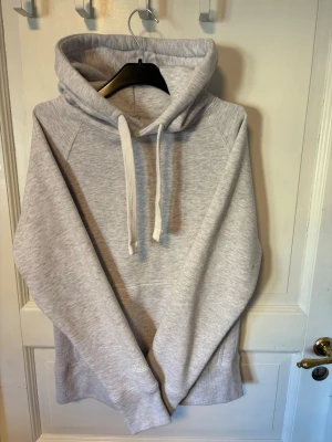 Russemerch hoodie - En stilren Russemerch hoodie med huva. Hoodien har en klassisk känguruficka framtill och ribbade muddar vid ärmslut och nederkant. Perfekt för en avslappnad och trendig look.