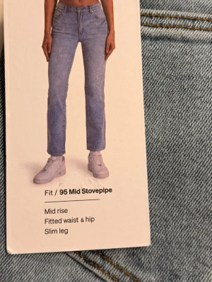 Ljusblå slim jeans från Abrand - Säljer ett par ljusblå jeans från Abrand, modell 95 Mid Stovepipe. Jeansen har mid rise, smal passform i benen och sitter snyggt i midja och höft. Klassisk femficksmodell med läderpatch bak. Perfekta för en trendig och avslappnad look.