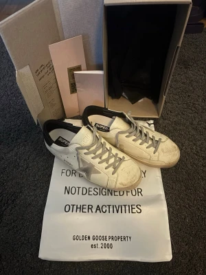 Golden Goose sneakers - Vita Golden Goose sneakers, bra skick. Smutset vid tårna går enkelt att rengöra, kommer med box och dustbag. Väldigt bra skick. Strl 44. Pris går att diskutera vid snabb affär!!
