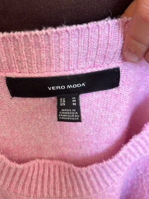 Ljusrosa stickad tröja Vero Moda - Mysig ljusrosa stickad tröja från Vero Moda med rund halsringning och ribbade muddar vid ärmslut och nederkant. Perfekt för dig som gillar en enkel men söt look. Tröjan har en avslappnad passform och är superbekväm.