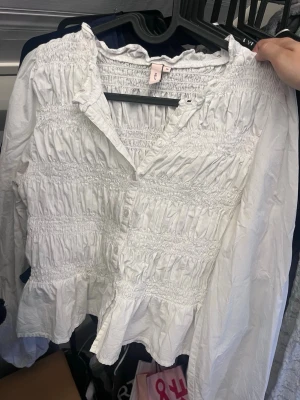 Vit smockad blus från Nelly  - Jätte fin blus från Nelly som jag köpte här på Plick men personen sa inte att det fanns små fläckar och att den va i storlek 36 då jag ville ha 34! Fläckarna syns knappt och hade kunnat använda den men den är i fel storlek!💕