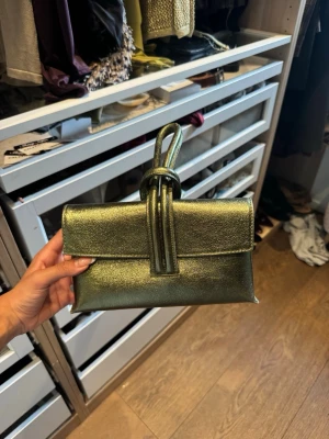 Grön handväska - Säljer min super fina gröna handväska jag köpte i Italien. Perfekt till en svart/vit outfit, eller en fin sommar outfit. En touch med färg. 
