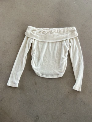 Vit offshoulder topp från SHEIN - Trendig vit offshoulder topp från SHEIN i mjukt material. Långärmad modell med bred krage som vilar över axlarna. Perfekt för dig som vill ha en stilren och enkel topp med en twist. Passar snyggt till både jeans och kjol.