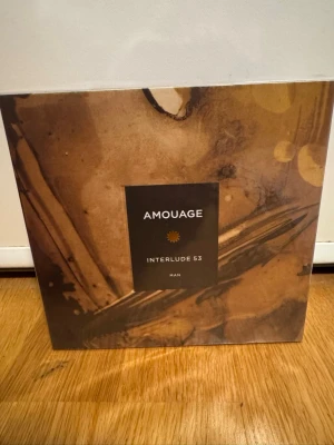 Amouage Interlude 53 Man Parfym - Lyxig parfym från Amouage, Interlude 53 Man. Kommer i en elegant brun och guldig förpackning med konstnärligt mönster. Parfymen har noter av bergamott, oregano, rökelse, läder och sandelträ. Perfekt för dig som gillar unika och djupa dofter. Oöppnad och inplastad.