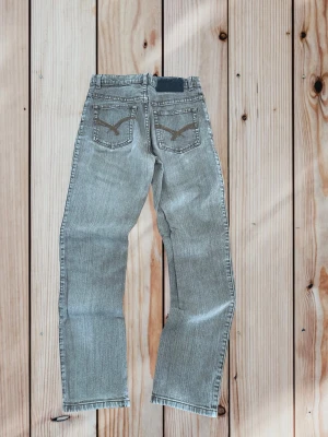 Gråa 2000s jeans  - Supergulliga jeans från 2000-talet, storlek small, super gullig fade!! Gjorda av Flash jeans, ganska y2k, passar liksom en vanlig casual fit! De är ju från 2000-talet så storleken S kanske är mer som en XS nu! 