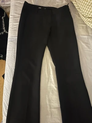 Svarta kostymbyxor från BikBok - Stilrena svarta kostymbyxor från BikBok med klassisk rak passform och pressveck. Byxorna har diskreta fickor. Perfekta för en clean och snygg look. Materialet känns mjukt och skönt. Vill ej ha längre pågrund av att den är för stor för mig nu pga vikt nedgång (jag är 170cm denna är regular) 