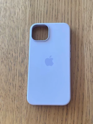 Ljuslila Apple iPhone MagSafe-skal - Snyggt ljuslila mobilskal från Apple till iPhone med MagSafe-kompatibilitet. Skalet är gjort i mjukt silikon med en slät yta och har Apples logga på baksidan. Passar perfekt för dig som vill ha ett stilrent och modernt skydd till din mobil.