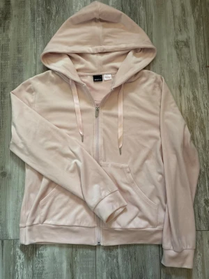 ljus rosa zip up hoodie i velour från Gina Tricot - Mjuk och skön ljus rosa zip up hoodie i velour från Gina Tricot. Är i storlek L men passar också som en lös M, perfekt för en avslappnad och trendig look!