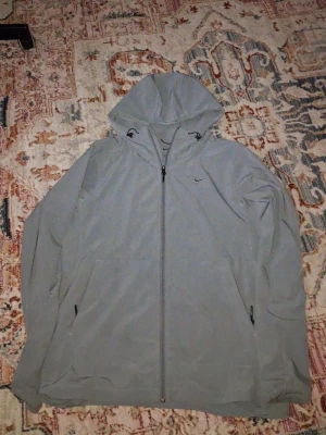 Nike vindjacka - Nikejacka, 2 skador en vid loggan en där bak.
