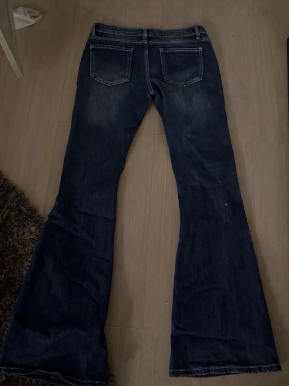 Mörkblå utsvängda jeans med slitningar - 1