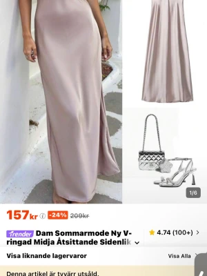 Champagnefärgad långklänning i satin - Elegant långklänning i champagnefärgad satin med v-ringad halsringning och åtsittande midja. Klänningen har en slits på sidan och är ärmlös, vilket ger en stilren och modern look. Perfekt för dig som vill sticka ut med en lyxig känsla.