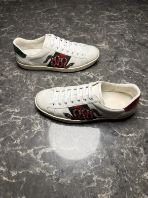 Gucci ace snake - Säljer ett par otroligt snygga skor från det exklusiva italienska märket Gucci! Skorna är i mycket bra skick, skulle säga ungefär 9/10. Nypris ligger på över 8000kronor men jag säljer dessa för endast 1999 och kan gå ner i pris ännu mer vid snabb affär! Skorna är i storlek 41,5 men passar även 42. Skriv gärna ifall det är några funderingar, allt bästa SkoKapet