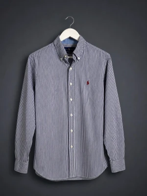 Randig skjorta från Ralph Lauren - Säljer en stilren och tidlös Ralph Lauren skjorta i blått och vitt randigt mönster med broderad logga på bröstet. Perfekt för både vardag, kontor, business casual eller mer uppklädda tillfällen. Skjortan är i fint använt skick och passar utmärkt året runt.  ✅ Original Ralph Lauren ✅ Klassisk button-down krage ✅ Blå/vita ränder ✅ Broderad Polo-logga ✅ Bekväm och stilren passform ✅ Perfekt till jeans, chinos eller kostymbyxor  📏 Storlek: M 📍 Skick: Nästantill ny  Pris kan diskutera
