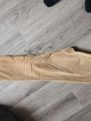 Beiga manchesterbyxor från Ralph Lauren  - Säljer ett par snygga beiga manchesterbyxor från Lauren Ralph Lauren. Byxorna har klassisk femficksmodell, raka ben och bälteshällor. Tillverkade i mjuk manchester med tydlig struktur, perfekta för en avslappnad och trendig look. Storlek 6, 38, S/M