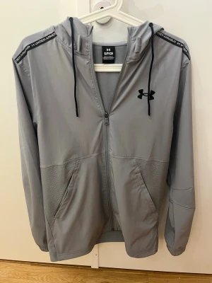 Under Armour windbreaker  - Tja, säljer en riktigt snygg vindjacka från Under Armour i storlek S för 550:-. Den är väldigt bra skick och använd väldigt lite. Perfekt för sport och vardag och för blåsiga dagar. Hör av er för fler bilder! Byte funkar