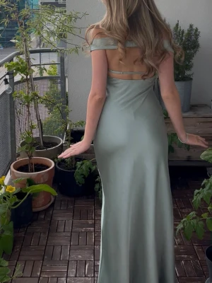 Balklänning  - Elegant ljusgrön/ turkos långklänning med offshoulder-design och öppen rygg. Klänningen har en figurnära passform, uppsydd för att passa 162-167 cm långa personer med klackskor💕