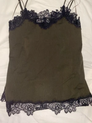 Spetslinne  - Ett militär grönt linne från Zara som är tajt och har en slit på sidan. Jag säljer den här för att den är för liten och aldrig fått användning för den. 