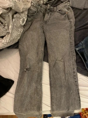 Grå raka jeans från HM - Säljer ett par grå raka jeans från HM med klassisk femficksmodell och dragkedjegylf. Jeansen har en tvättad look och är tillverkade i bomull. Perfekta till en avslappnad stil och passar till det mesta i garderoben.