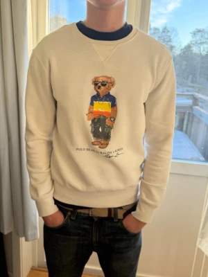 POLO BEAR RAULPH LAUREN HOODIE - Vit polo bear raulph lauren hoodie, jag är 178, väldigt bra skick endast använd ett fåtal gånger, inga fläckar osv, hör av dig om du har några fler frågor har även kvitto på den om de så önskas