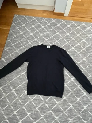 Marinblå stickad tröja - En marinblå stickad tröja ifrån bläck, storlek M.